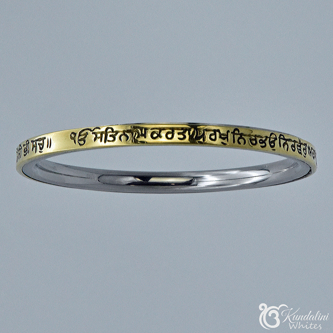 Steel and brass bracelet with engraved text on a gray background