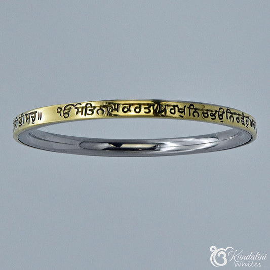 Steel and brass bracelet with engraved text on a gray background