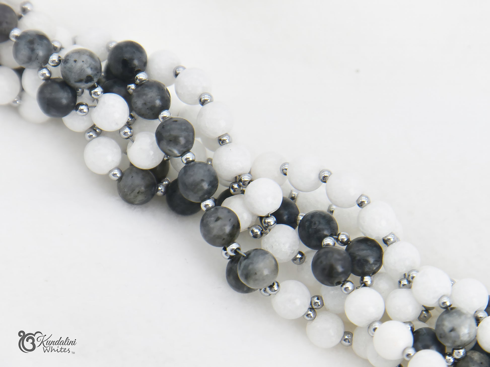 Tantric necklace with black, white, and gray beads on a white background 