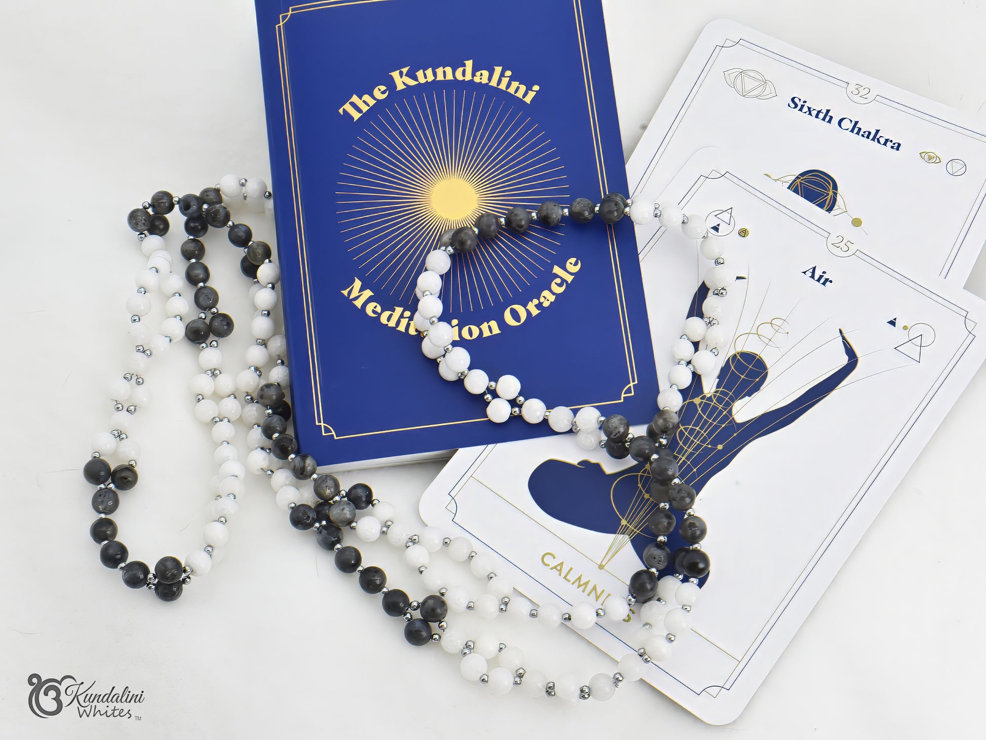 Kundalini Meditation Oracle book with a tantric mala and cards on a white background