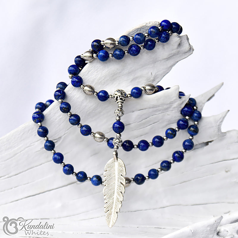 Lapis lazuli mala with a silver feather pendant on a white background