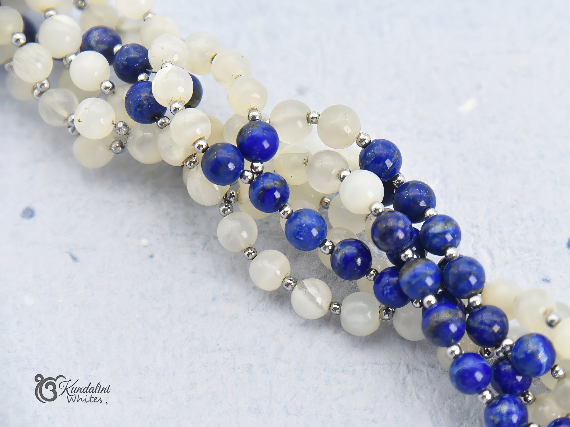 Close-up of a blue and white tantric necklace on a light background