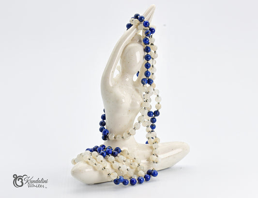White ceramic sculpture of a yogi holding a blue and cream tantric necklace on a white background