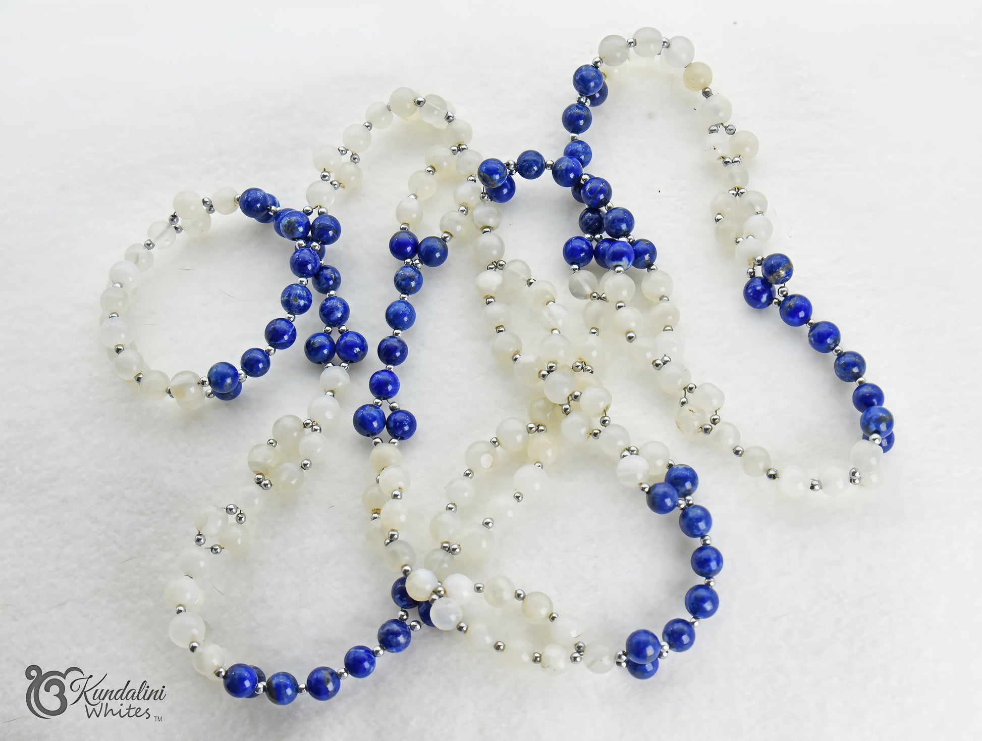 Tantric necklace with blue and cream beads on a white background