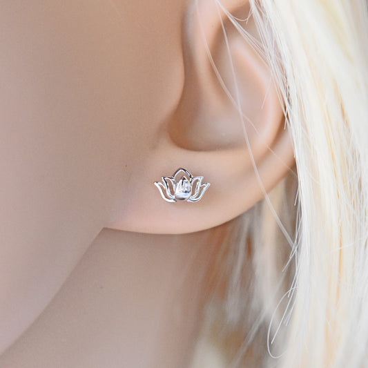 Silver lotus flower earring worn on a model's ear with a neutral background
