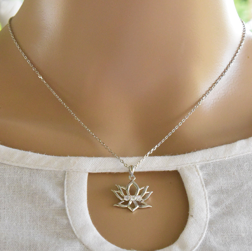Silver necklace with a lotus flower pendant on a mannequin.