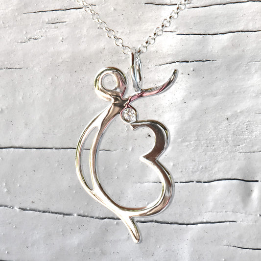 Silver Ek Ong Kaar pendant with a small diamond on a silver chain against a textured gray background