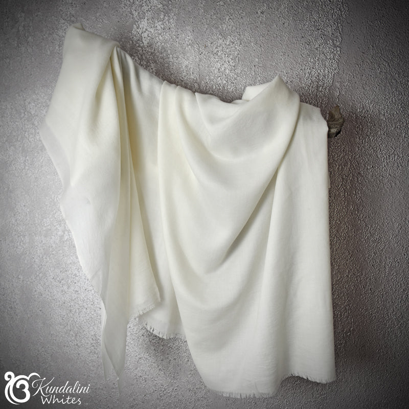 White shawldraped over a textured gray wall