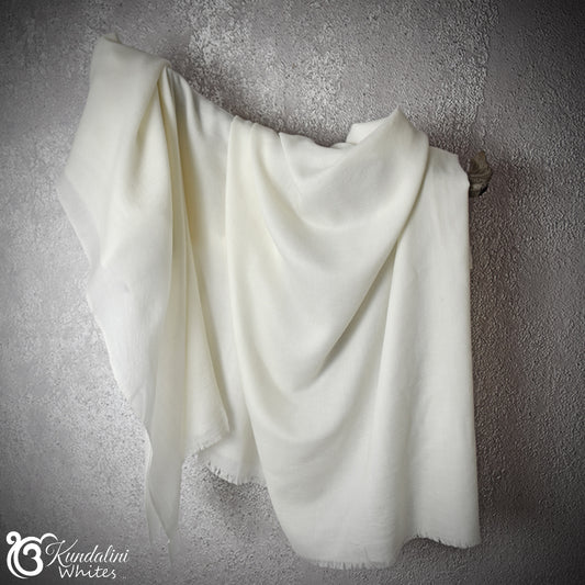White shawldraped over a textured gray wall