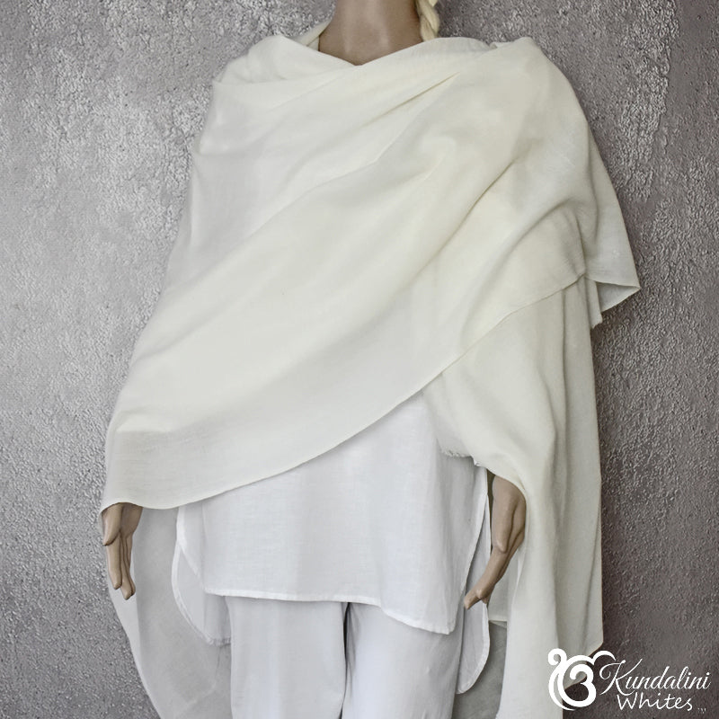 Mannequin wearing a white shawl against a textured gray background