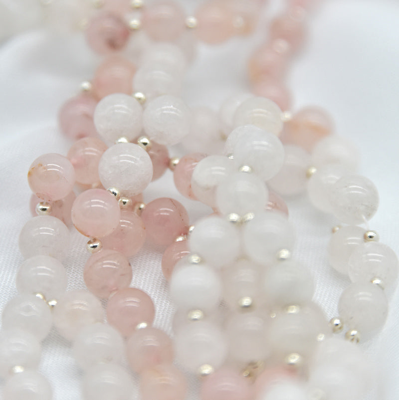 Close-up of pink and white beaded strands on a white background
