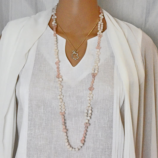 Long tantric rose quartz and white agate gemstone mala being worn in Kundalini practice.