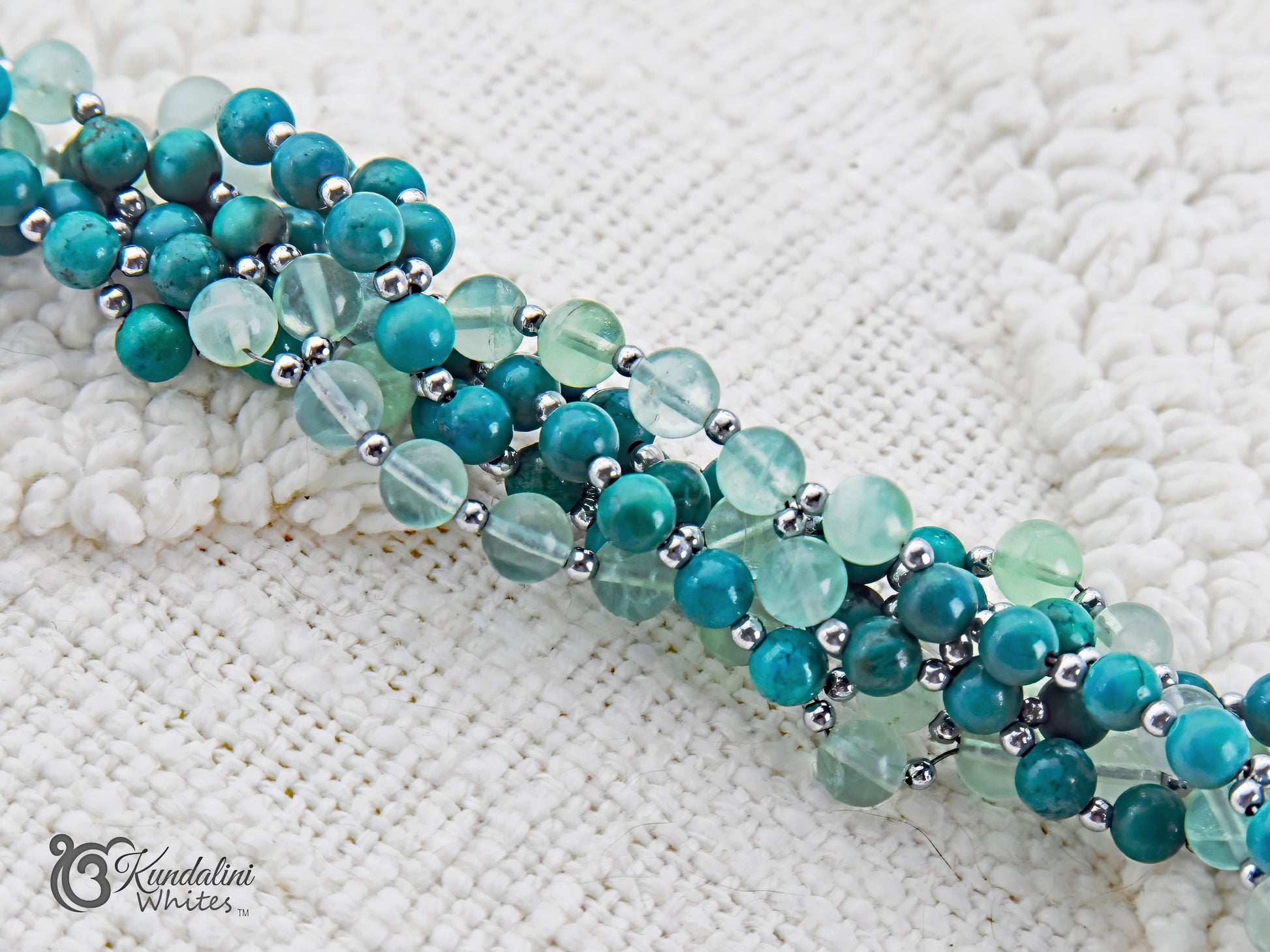 Turquoise beaded tantric mala closeup on a textured white surface