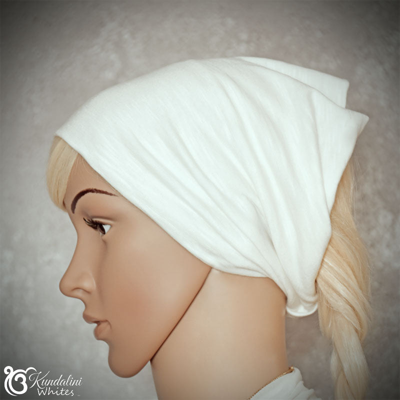 Mannequin head wearing a white headband with 'Kundalini Whites' branding.