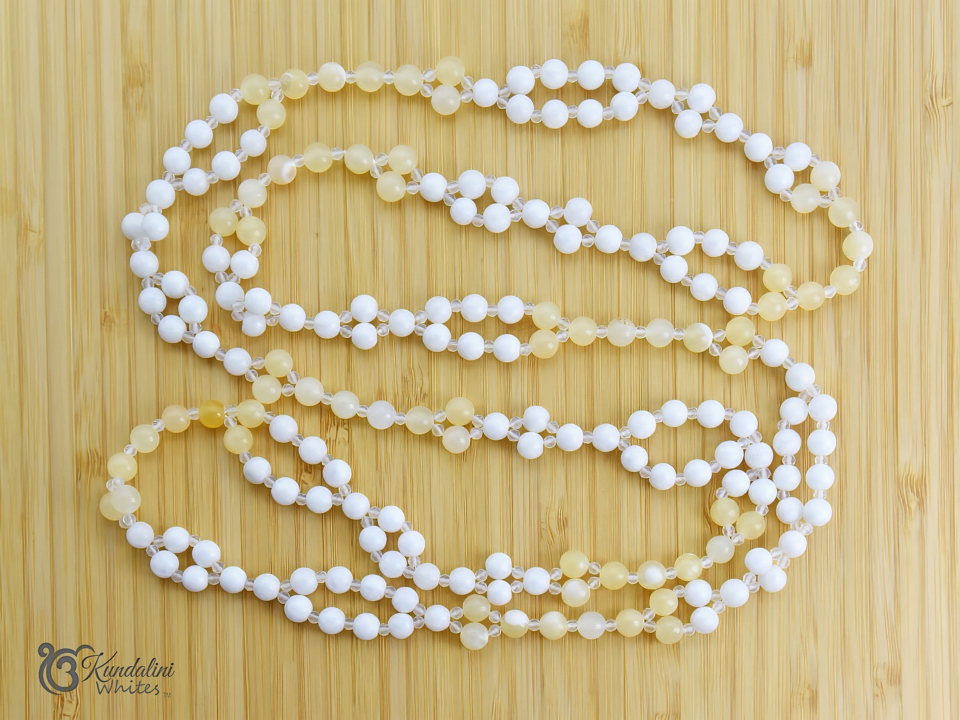 White and yellow tantric necklace on a wooden surface.