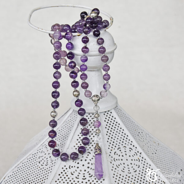 108 8mm bead amethyst mala gathered on tope of a metal lantern