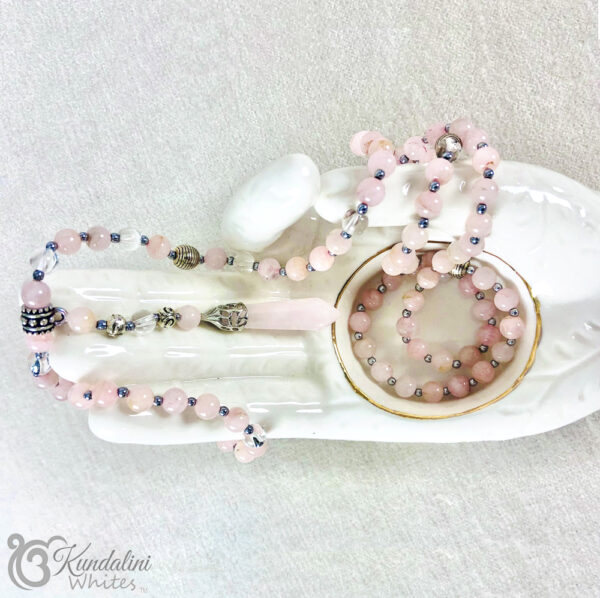 Rose quartz mala displayed on porcelain hand