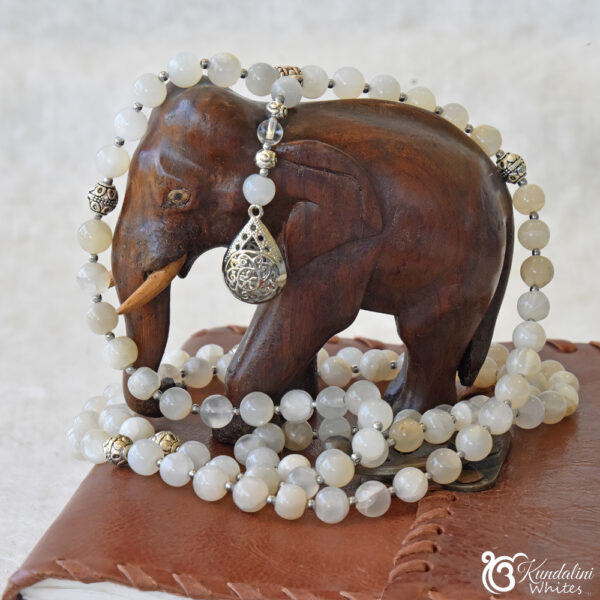 Moonstone 108 mala over and around a wooden elephant