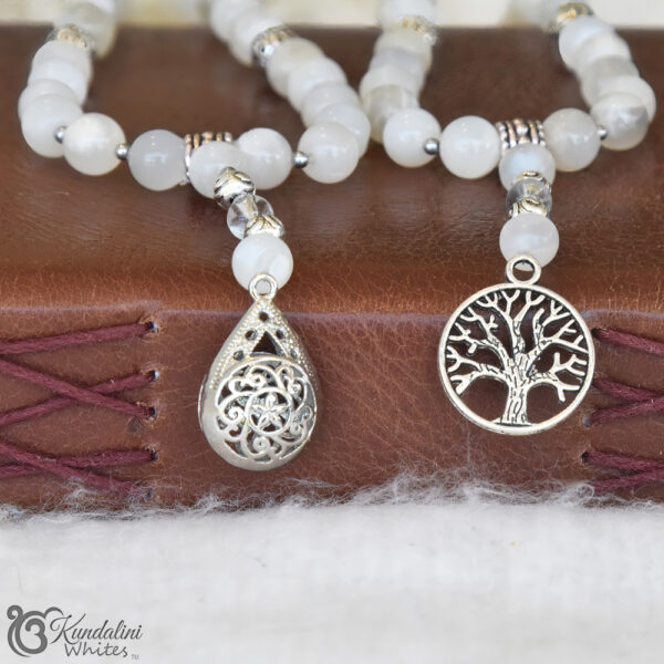 Closeup of droplet, and Tree of Life pendants attached to a moonstone mala