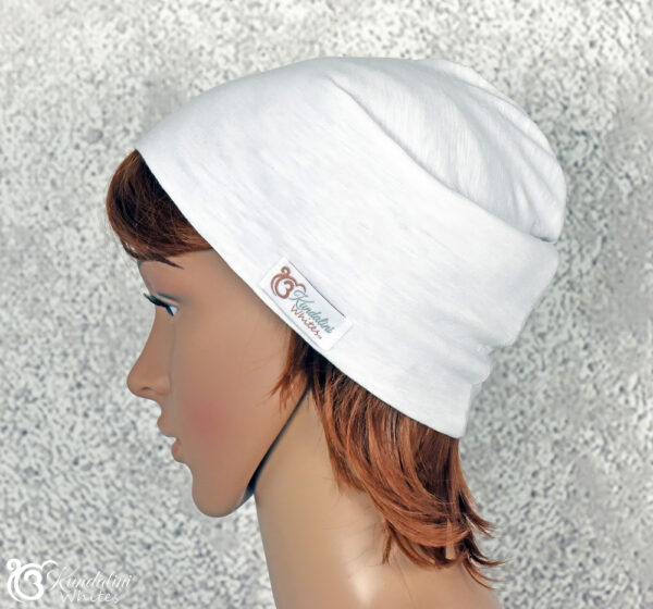 Sideview of female model wearing a white cotton beanie