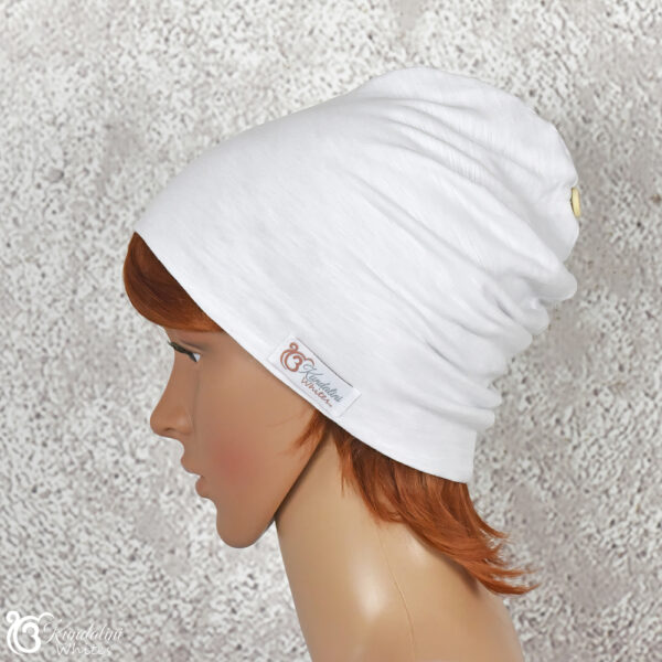 Side view of female model wearing a white cotton beanie in slouch style